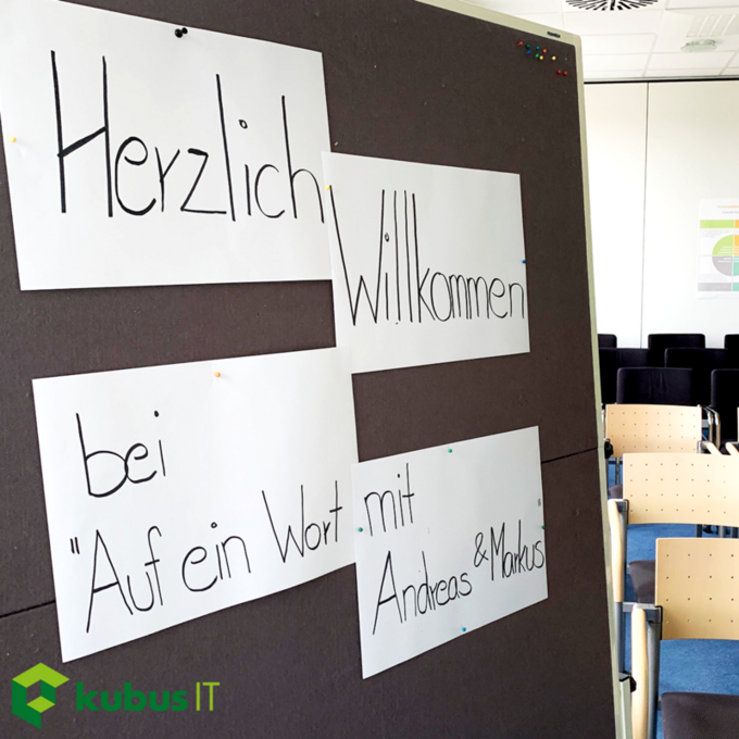 Auf einem Flipchart steht "Herzlich Willkommen bei "Auf ein Wort mit Andreas & Markus"