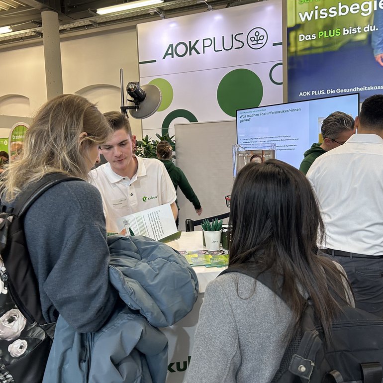 Interessierte junge Menschen informieren sich am Messestand über die Karrieremöglichkeiten bei der kubus IT