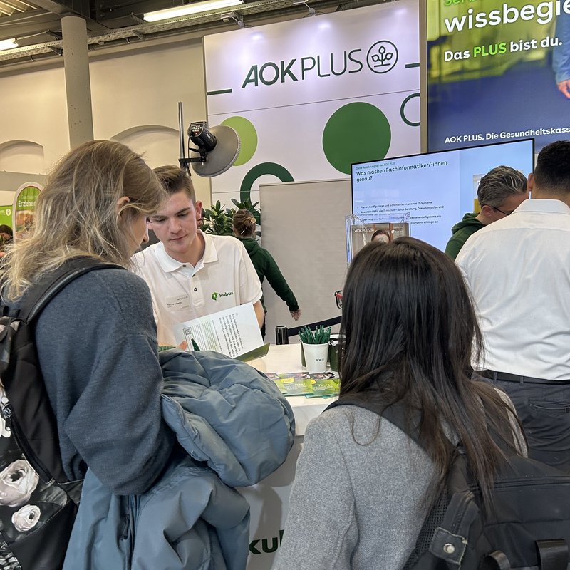 Interessierte junge Menschen informieren sich am Messestand über die Karrieremöglichkeiten bei der kubus IT